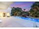 Backyard pool area showcasing a rock waterfall feature, lush landscaping, and a private patio at 7185 Ranchito Cir, Las Vegas, NV 89120