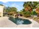 Stunning backyard pool showcasing lush landscaping, a rock waterfall, and clear, refreshing water at 7185 Ranchito Cir, Las Vegas, NV 89120