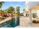 Custom outdoor living space includes pool, rock waterfall, mature landscaping and covered patio at 7185 Ranchito Cir, Las Vegas, NV 89120
