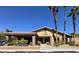 Clubhouse with covered parking, desert landscaping, and mature palm trees against a clear blue sky at 7300 Pirates Cove Rd # 2045, Las Vegas, NV 89145