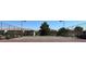 Outdoor tennis court surrounded by a chain-link fence and mature shade trees on a sunny day at 7300 Pirates Cove Rd # 2045, Las Vegas, NV 89145