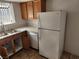 Kitchen with white refrigerator, double basin sink, and wood cabinets and drawers at 7300 Pirates Cove Rd # 2045, Las Vegas, NV 89145