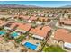 Expansive aerial view of a desert community featuring tile roofs, private pools, and mountain views at 7473 Crystal Clear Ave, Las Vegas, NV 89113