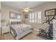 Cozy bedroom featuring wood floors, neutral paint, a ceiling fan, and a window with shutters at 7473 Crystal Clear Ave, Las Vegas, NV 89113