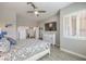Bright bedroom featuring stylish ceiling fan, television, and plantation shutters at 7473 Crystal Clear Ave, Las Vegas, NV 89113