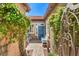Inviting front entrance with a blue door, brick walkway, and lush flowering vines at 7473 Crystal Clear Ave, Las Vegas, NV 89113