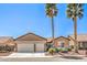 Charming single-story home with a three-car garage, desert landscaping, and two palm trees at 7473 Crystal Clear Ave, Las Vegas, NV 89113