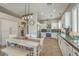 Well-lit kitchen with white cabinetry, stainless steel appliances, and a dining area at 7473 Crystal Clear Ave, Las Vegas, NV 89113