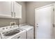 A well-lit laundry room with a newer washer and dryer and convenient storage cabinets at 7473 Crystal Clear Ave, Las Vegas, NV 89113