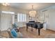 Elegant living room with a piano, chandelier, and tile flooring at 7473 Crystal Clear Ave, Las Vegas, NV 89113