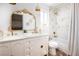 Stylish bathroom featuring a double vanity with elegant mirror, combined tub and shower, and natural light at 7825 Desert Bell Ave, Las Vegas, NV 89128