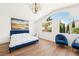 Bright bedroom featuring large windows, a blue accent bed, and stylish decor at 7825 Desert Bell Ave, Las Vegas, NV 89128