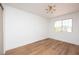 Bright bedroom features wood flooring, a large window with neighborhood views, and simple light fixture at 7825 Desert Bell Ave, Las Vegas, NV 89128