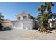Attractive two-story home featuring a three-car garage, terracotta tile roof, and lush desert landscaping at 7825 Desert Bell Ave, Las Vegas, NV 89128