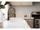Close up of a white kitchen counter with a stainless steel stove and faucet at 7825 Desert Bell Ave, Las Vegas, NV 89128