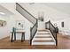 Elegant staircase featuring black railings, wood accents, and contemporary artwork at 7825 Desert Bell Ave, Las Vegas, NV 89128