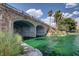 Stone bridge spanning over water with lush landscaping and palm trees at 8052 Marbella Cir, Las Vegas, NV 89128