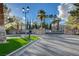 Welcoming entrance to a gated community with lush landscaping, decorative street lamps, and manicured green spaces at 8052 Marbella Cir, Las Vegas, NV 89128