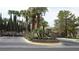 Landscaped entrance featuring palm trees and manicured bushes around a gated community at 8052 Marbella Cir, Las Vegas, NV 89128