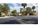 Gated community entrance features well-kept landscaping with mature palm trees at 8052 Marbella Cir, Las Vegas, NV 89128