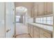 Hallway with tiled floors featuring cabinets and counter space, leading into a carpeted living space at 8052 Marbella Cir, Las Vegas, NV 89128