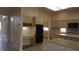Well-lit kitchen with tiled floors, abundant cabinet storage, black appliances, and breakfast bar with room for seating at 8052 Marbella Cir, Las Vegas, NV 89128