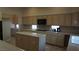 Bright kitchen featuring light cabinetry, tile countertops, modern appliances, and kitchen island at 8052 Marbella Cir, Las Vegas, NV 89128