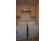 Efficient laundry room with washer, dryer, and overhead cabinets for storage at 8052 Marbella Cir, Las Vegas, NV 89128