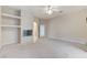 Spacious living room with a fireplace, ceiling fan, and carpeted floors, adjacent to an open doorway at 8052 Marbella Cir, Las Vegas, NV 89128