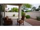 A covered patio with textured chairs overlooks the landscaped backyard at 8052 Marbella Cir, Las Vegas, NV 89128