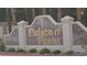 Neighborhood sign for Pelican Point featuring gold lettering and manicured shrubs at 8052 Marbella Cir, Las Vegas, NV 89128