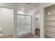 Bathroom with glass-enclosed shower, tile surround and next to shelved closet at 816 Sand Camel Ct, North Las Vegas, NV 89081