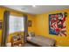 Vibrant yellow bedroom featuring a single bed, window with blinds, and colorful decor for a cheerful ambiance at 816 Sand Camel Ct, North Las Vegas, NV 89081