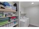 Functional laundry room with shelving for storage, modern washer and dryer units, and organized space at 816 Sand Camel Ct, North Las Vegas, NV 89081