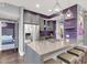 Modern kitchen featuring an island with bar seating, stainless steel appliances, and trendy purple backsplash at 9000 S Las Vegas Blvd # 2222, Las Vegas, NV 89123