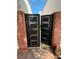 Striking black steel entry gate framed by brick pillars and open to green space at 940 Vegas Valley Dr, Las Vegas, NV 89109