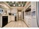 A galley-style kitchen with white cabinets and appliances and tile floors at 940 Vegas Valley Dr, Las Vegas, NV 89109