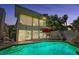 Backyard pool with an outdoor dining area, palm trees, and beautiful landscaping, ready for a night swim at 940 Vegas Valley Dr, Las Vegas, NV 89109