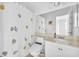Bright bathroom features a shower-tub combo with sea-themed shower curtain and a white single sink vanity at 9588 Comiskey Ct, Las Vegas, NV 89148