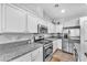 Modern kitchen featuring stainless steel appliances, white cabinets, and ample counter space at 9588 Comiskey Ct, Las Vegas, NV 89148