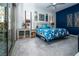 Spacious bedroom with a blue accent wall, comfortable bed, and sliding glass doors to the exterior at 9858 Gemstone Sunset Ave, Las Vegas, NV 89148