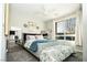 A well-lit bedroom with a cozy bed, mirrored nightstand, and a view of the outdoors at 9858 Gemstone Sunset Ave, Las Vegas, NV 89148