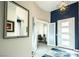 Elegant home foyer with tile flooring, a large mirror, and an adjacent home office at 9858 Gemstone Sunset Ave, Las Vegas, NV 89148