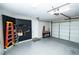 Garage features an epoxy floor, an overhead door, and slat wall with a ladder at 9858 Gemstone Sunset Ave, Las Vegas, NV 89148