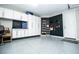 The garage features epoxy flooring, black slat wall, and white cabinets for storage at 9858 Gemstone Sunset Ave, Las Vegas, NV 89148