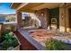 Inviting outdoor patio with stone columns, manicured greenery and a decorative water fountain at 9858 Gemstone Sunset Ave, Las Vegas, NV 89148