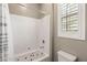 Bright bathroom features a tub with shower and a shuttered window at 10086 Mountain Foothills Ave, Las Vegas, NV 89149
