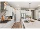 Bright kitchen featuring white cabinets, stainless steel appliances, backsplash, and an island with a sink at 10086 Mountain Foothills Ave, Las Vegas, NV 89149