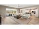 Spacious living room with a plush sectional, wood-look floors, and open access to the kitchen and backyard at 10086 Mountain Foothills Ave, Las Vegas, NV 89149