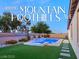 Beautiful backyard pool and spa with turf, stone pavers, and desert landscaping; a luxurious outdoor oasis at 10086 Mountain Foothills Ave, Las Vegas, NV 89149